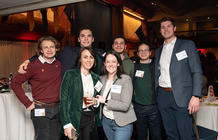 Alumni smiling for a photo at the holiday party